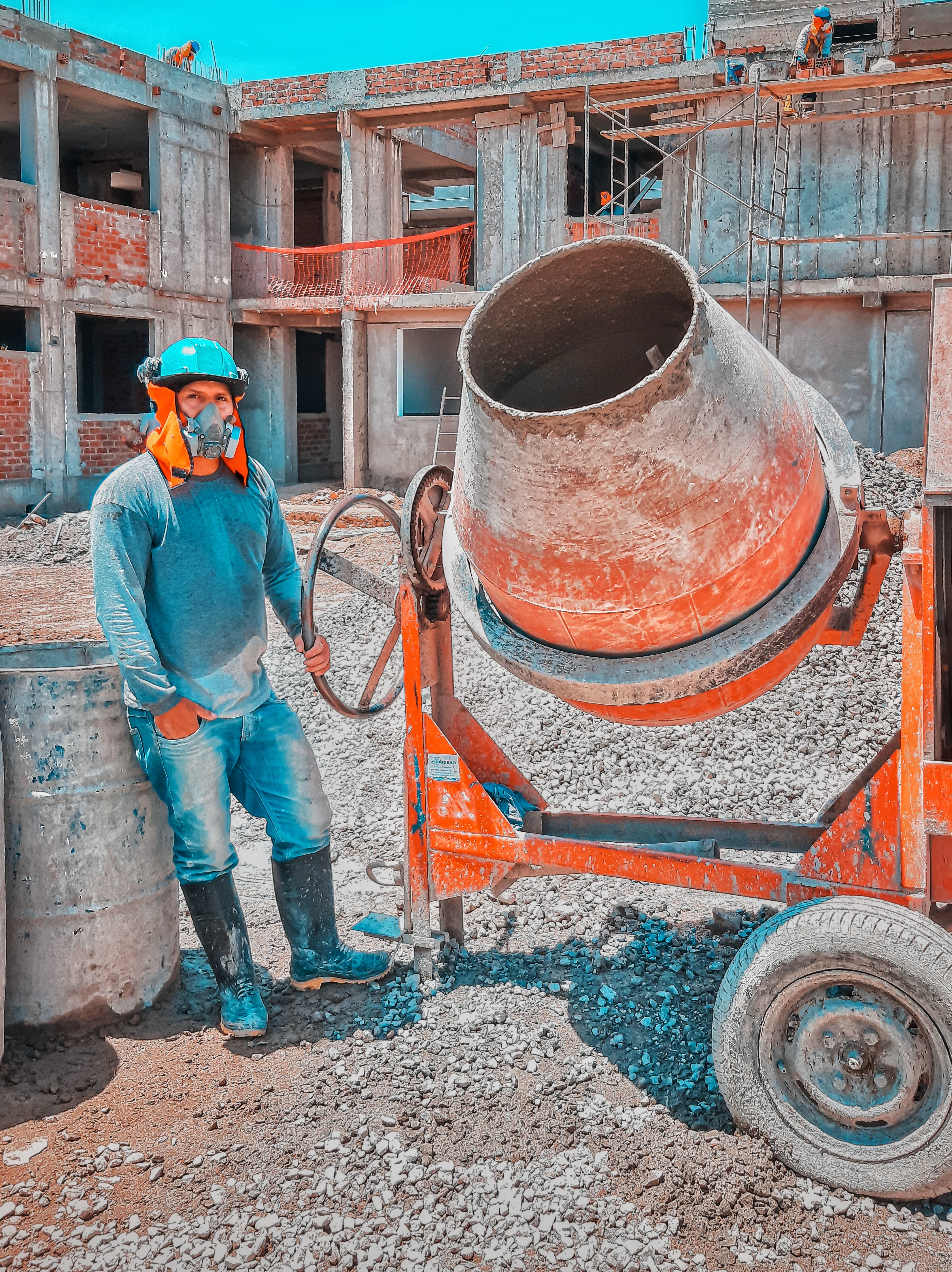 Man wearing an CNCS T-shirt carrying a plank of wood on a building site